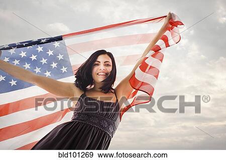 Stock Photo - Caucasian woman holding American flag. Fotosearch