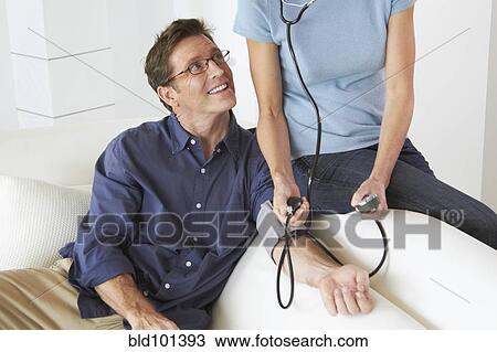 Caucasian woman taking husband's blood pressure View Large Photo Image Stock Image - Caucasian woman taking husband's blood pressure. Fotosearch