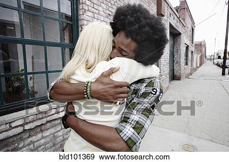 Stock Photo - Couple hugging on sidewalk. Fotosearch