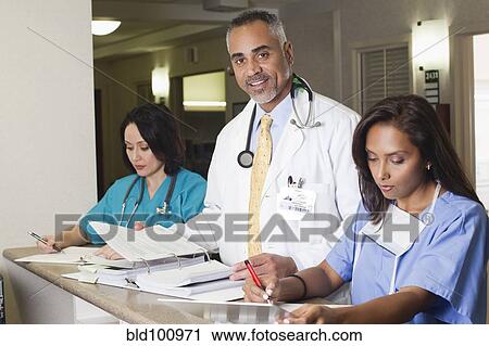 Stock Image - Doctor and nurses working in hospital. Fotosearch
