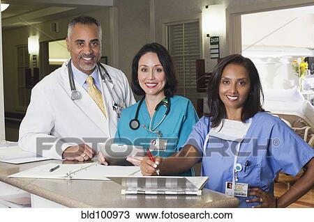 Stock Image - Doctor and nurses working in hospital. Fotosearch