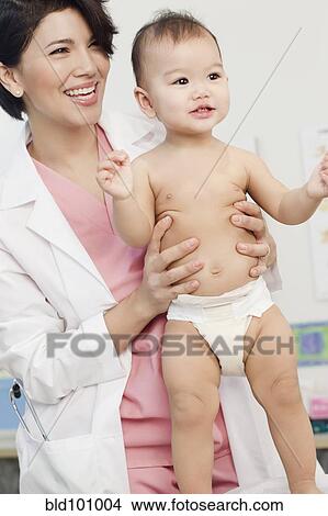 Picture - Doctor examining baby in doctor's office. Fotosearch