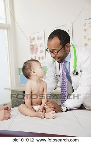 Doctor examining baby in doctor's office View Large Photo Image Stock Image - Doctor examining baby in doctor's office. Fotosearch