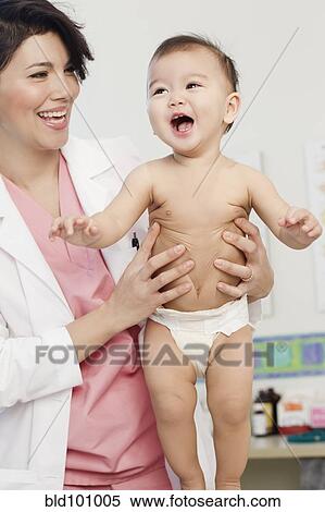 Stock Photography - Doctor examining baby in doctor's office. Fotosearch