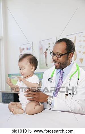 Stock Photography - Doctor examining baby in doctor's office. Fotosearch