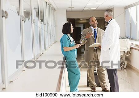 Stock Image - Doctors and drug salesman talking in hospital. Fotosearch
