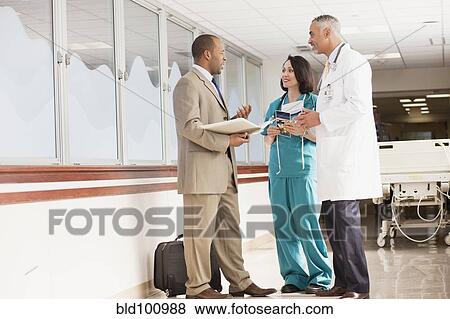 Stock Photo - Doctors and drug salesman talking in hospital. Fotosearch