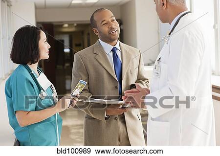 Stock Photo - Doctors and drug salesman talking in hospital. Fotosearch