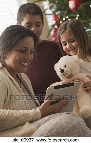 Stock Photo - Family looking at digital tablet on Christmas morning. Fotosearch