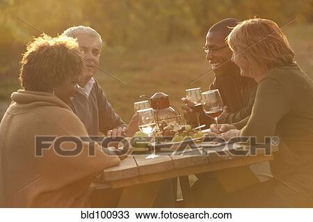Friends having picnic and drinking wine View Large Photo Image Stock Image - Friends having picnic and drinking wine. Fotosearch