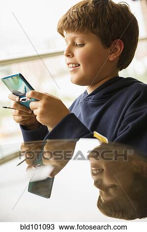 Stock Image - Hispanic boy playing video game. Fotosearch