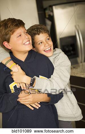 Stock Photo - Hispanic boys hugging. Fotosearch