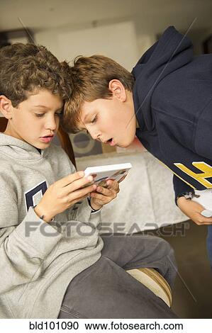 Stock Image - Hispanic boys playing video game. Fotosearch