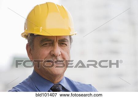 Stock Photo - Hispanic businessman wearing hard hat. Fotosearch