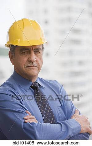 Stock Photo - Hispanic businessman wearing hard hat. Fotosearch