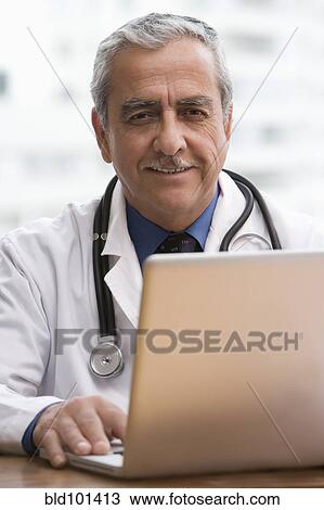 Hispanic doctor using laptop View Large Photo Image Stock Image - Hispanic doctor using laptop. Fotosearch