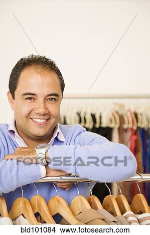 Hispanic man working in clothing store View Large Photo Image Picture - Hispanic man working in clothing store. Fotosearch