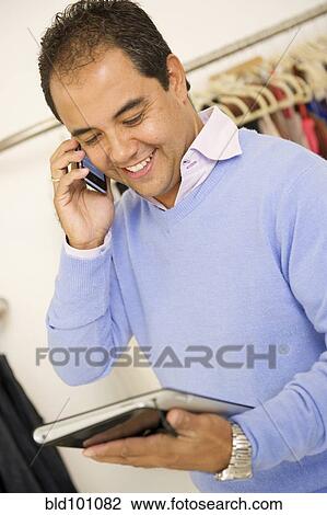 Hispanic man working in clothing store View Large Photo Image Stock Image - Hispanic man working in clothing store. Fotosearch