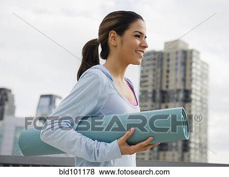 Hispanic woman carrying yoga mat View Large Photo Image Stock Photo - Hispanic woman carrying yoga mat. Fotosearch