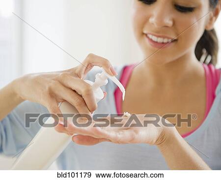 Hispanic woman putting on hand lotion View Large Photo Image Stock Photo - Hispanic woman putting on hand lotion. Fotosearch