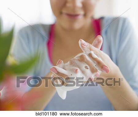 Stock Image - Hispanic woman washing hands. Fotosearch