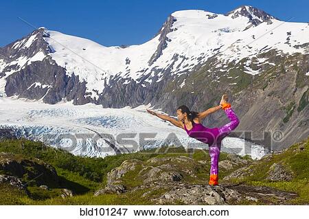 Stock Photo - Korean woman practicing yoga with mountain in background. Fotosearch