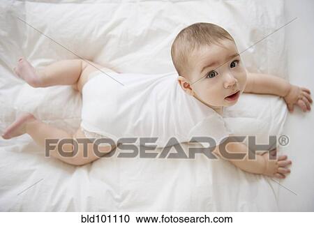 Stock Image - Mixed race baby boy laying on floor. Fotosearch