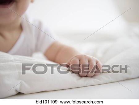 Stock Photo - Mixed race baby boy laying on floor. Fotosearch