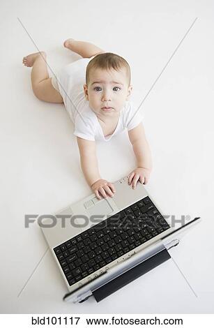 Stock Photo - Mixed race baby boy playing with laptop. Fotosearch