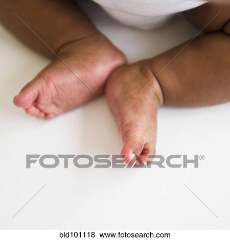 Stock Photo - Mixed race baby girl's feet. Fotosearch