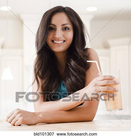 Stock Photo - Mixed race woman drinking smoothie. Fotosearch