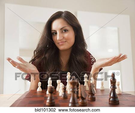 Stock Image - Mixed race woman playing chess. Fotosearch