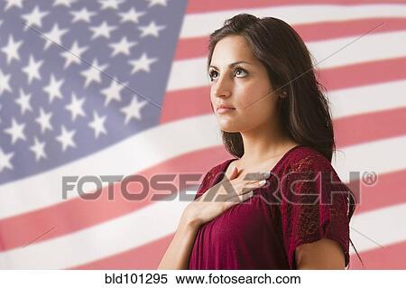 Stock Photography - Mixed race woman saluting American flag. Fotosearch