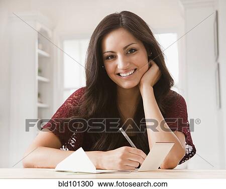 Stock Image - Mixed race woman writing card. Fotosearch