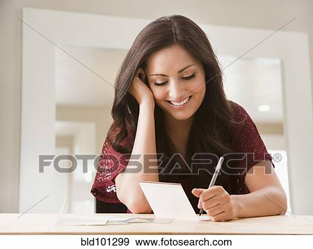 Stock Photo - Mixed race woman writing card. Fotosearch
