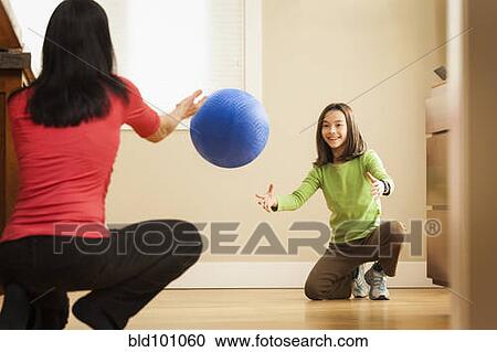 Stock Image - Mother and daughter playing with ball. Fotosearch