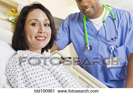 Stock Image - Nurse comforting patient in hospital. Fotosearch