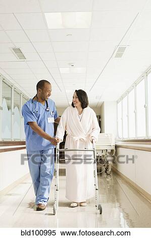 Stock Photography - Nurse helping patient use walker in hospital. Fotosearch
