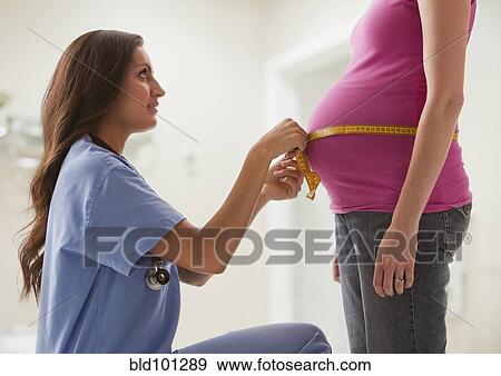 Stock Photo - Nurse measuring pregnant woman's stomach. Fotosearch