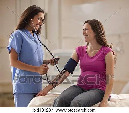 Stock Photo - Nurse taking pregnant mother's blood pressure. Fotosearch