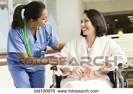Stock Photo - Nurse talking to patient in wheelchair in hospital. Fotosearch