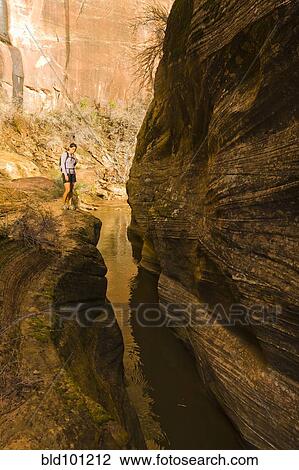 Stock Image - Persian woman hiking near canyon stream. Fotosearch