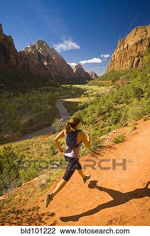 Stock Image - Persian woman running in canyon. Fotosearch