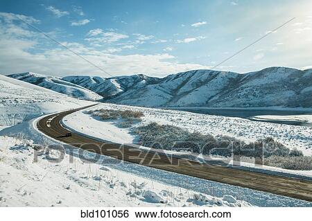 Stock Photograph - Road through snow covered valley. Fotosearch
