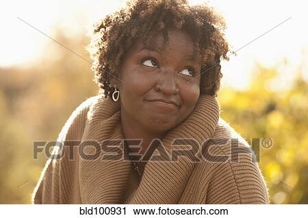 Stock Image - Smiling Black woman outdoors. Fotosearch