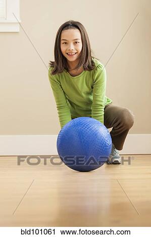 Stock Image - Smiling girl playing with ball. Fotosearch