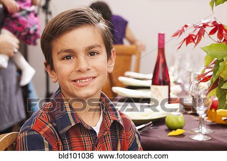 Stock Photograph - Smiling Hispanic boy at Thanksgiving dinner. Fotosearch