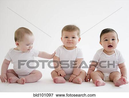 Stock Photo - Three babies sitting on floor. Fotosearch