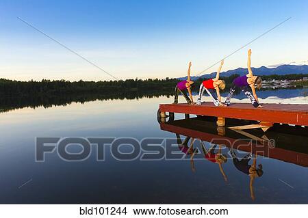 Woman exercising on lake pier View Large Photo Image Picture - Woman exercising on lake pier. Fotosearch