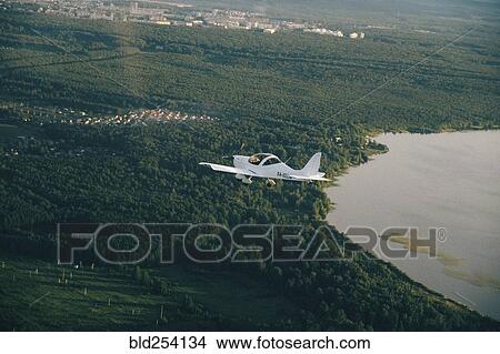 Aerial view of airplane flying over trees View Large Photo Image Picture - Aerial view of airplane flying over trees. Fotosearch